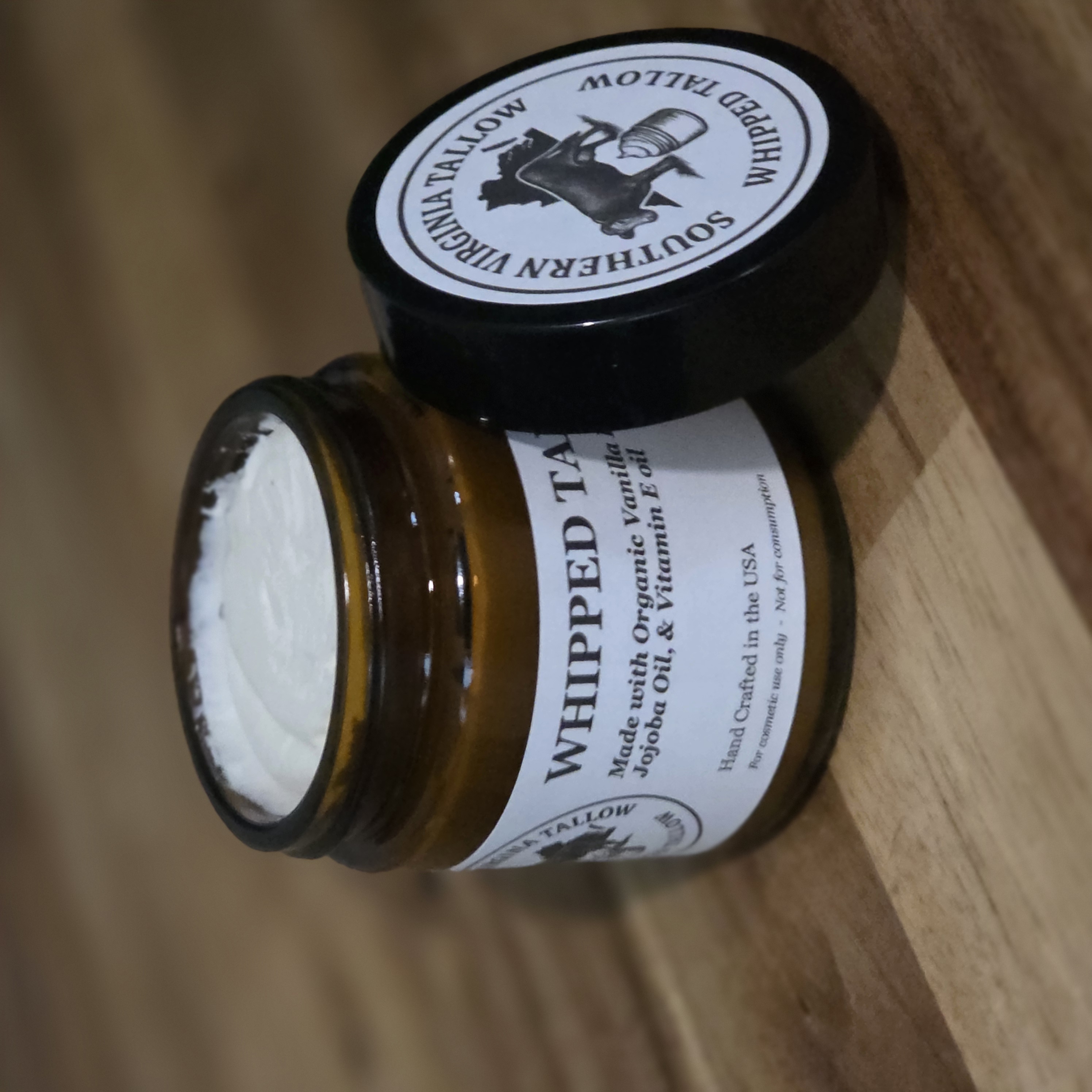 Open jar of Whipped Tallow beside the lid