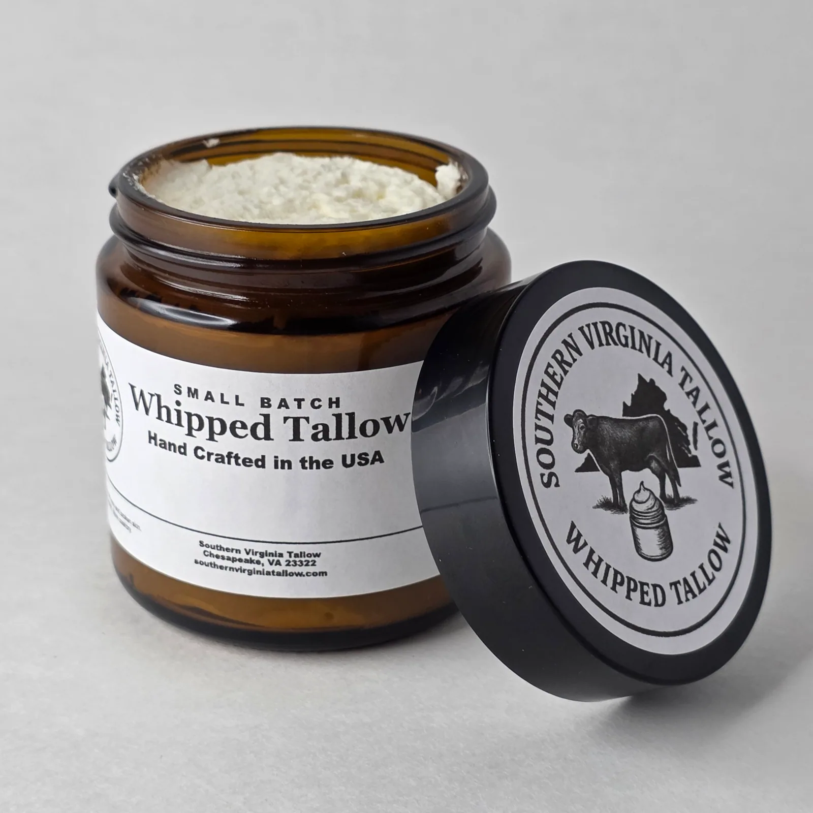 Open jar of Whipped Tallow beside the lid