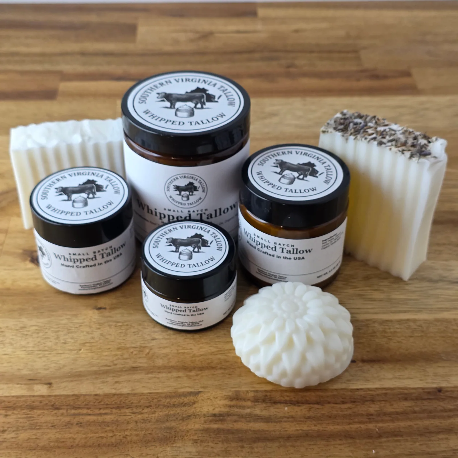 Southern Virginia Tallow jars and handmade soaps arranged on wood